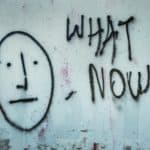 Graffiti zeigt Gesicht mit ernüchtertem Ausdruck und die Worte "What now?"